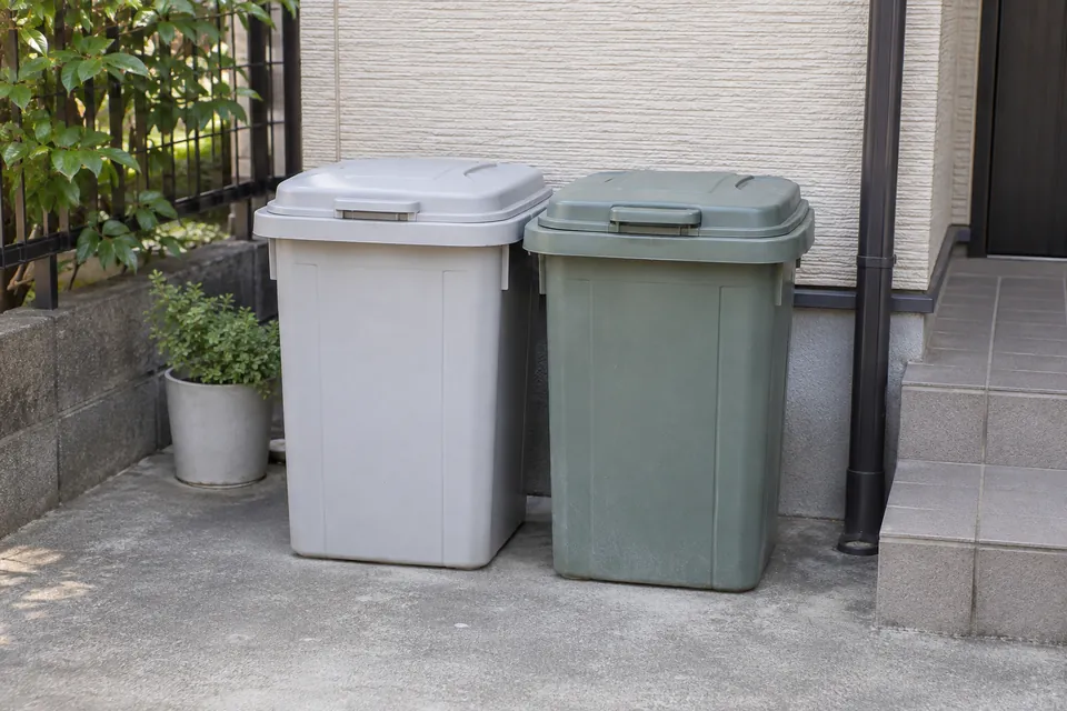 住宅の屋外に置かれたふた付きのごみ容器