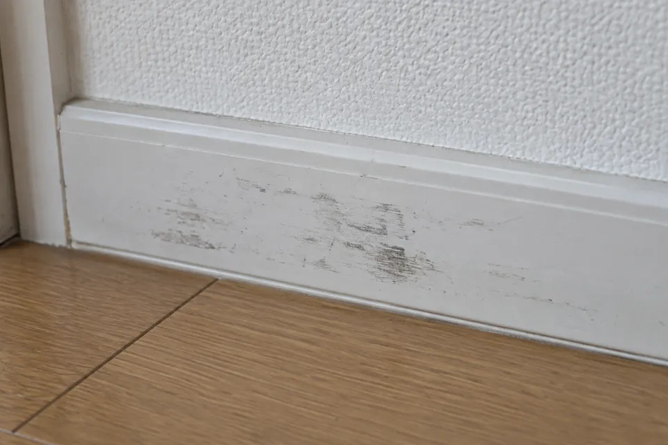 壁際の巾木に付いた黒い擦れた汚れ